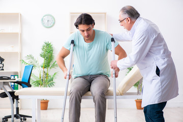 Young leg injured male patient visiting old doctor 