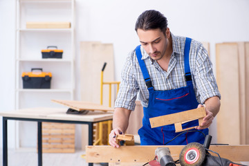 Young male carpenter working indoors 