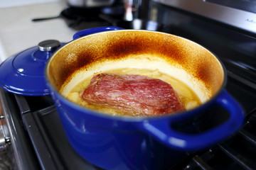 Corned beef brisket cooked in a Dutch oven, resting on the stove top.