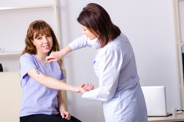 Young woman visiting female doctor physiotherapist 