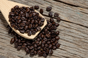 Coffee seeds in the wooden spoon put on the wood table