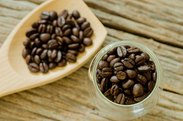 Top view of coffee seed in the wooden spoon and glass