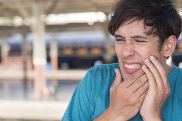 man suffering from toothache, tooth decay, tooth sensivity; oral health care concept