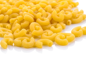 uncooked elbow macaroni on a white background