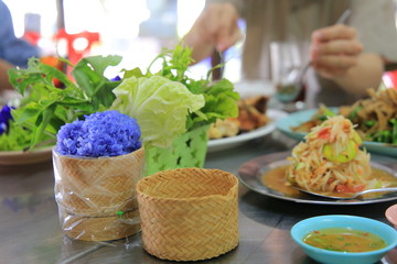 blue sticky rice. Colorful Thai northeastern cuisine food and papaya salad. special kind of sticky rice bake with Butterfly-pea flower herb.