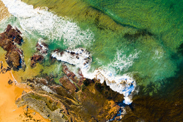 Emerald green ocean along rocky shoreline Sydney Australia beach
