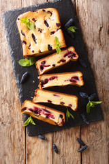 Berry cake with honeysuckle and mint on the board closeup on a table. Vertical top view from above
