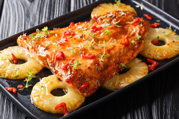 Thai salmon with pineapples and herbs baked in chili sweet sauce close-up on a plate. horizontal