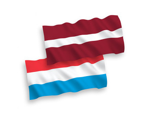 National vector fabric wave flags of Latvia and Luxembourg isolated on white background. 1 to 2 proportion.
