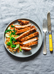 Crispy pork cutlet and quick pickled vegetables asian salad on grey background, top view