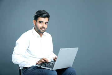 young indian employee with laptop