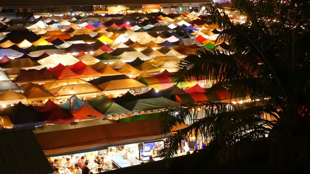 Illuminated tents of market at night. Top view of colorfull brightly illuminated tents of Ratchada Rot Fai Train Night Market on tourist street of Bangkok. Popular attraction, streetfood and shoping.