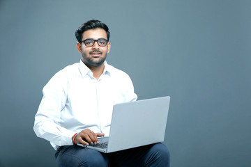 young indian employee with laptop