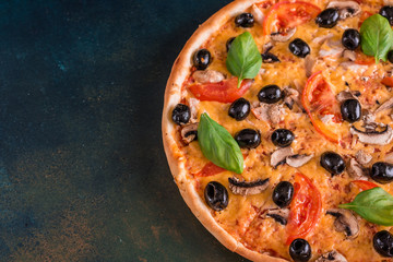 Tasty fresh hot pizza against a dark background. Pizza, food, vegetable, mushrooms.  It can be used as a background