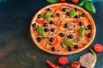 Tasty fresh hot pizza against a dark background. Pizza, food, vegetable, mushrooms.  It can be used as a background