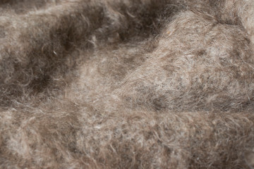grey hairy knitted fabric wool texture close-up as background