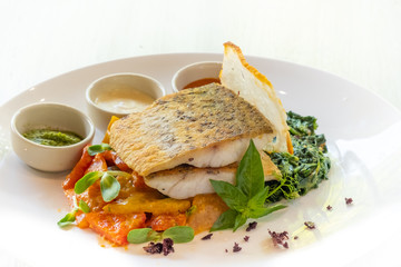 close up of pan seared grilled sea bass snapper fillet with healthy vegetables