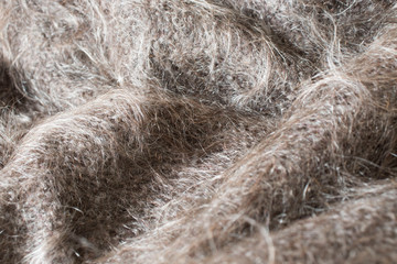 grey hairy knitted fabric wool texture close-up as background