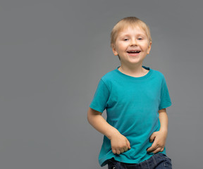 Portrait of happy smiling boy in blue t-shirt. Attractive kid in studio.