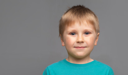 Portrait of happy smiling boy in blue t-shirt. Attractive kid in studio.