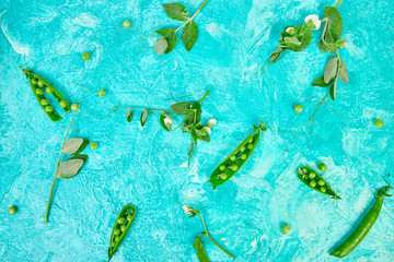 Flat lay composition with delicious fresh green peas on blue background. Vegan and vegetarian food concept.