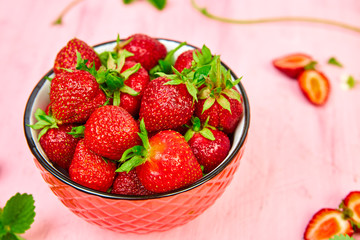 Ripe red strawberries on pink table, Strawberries in bowl. Fresh strawberries. Beautiful strawberries. Diet food. Healthy, vegan. Close up.