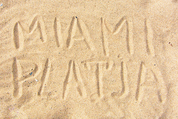 handwritten by the "Miami" on the sea sand