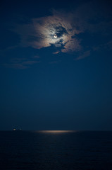 Full moon in a cloud and the sea beautiful night.