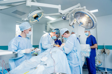 Spinal surgery. Group of surgeons in operating room with surgery equipment. Laminectomy