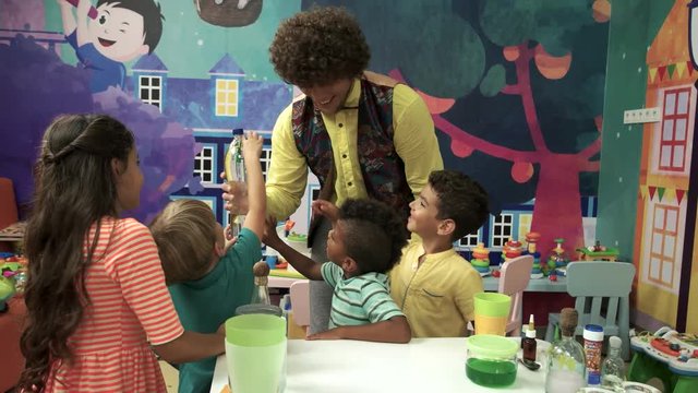 Entertaining and educational show for kids. Children having fun in playground zone indoor. Science experiment on Birthday party.
