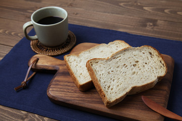 木のまな板にのせた トースト くるみ入り 食パンとコーヒー テーブル