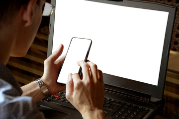 Man working on his laptop with mobile phone