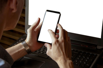 Man working on his laptop with mobile phone