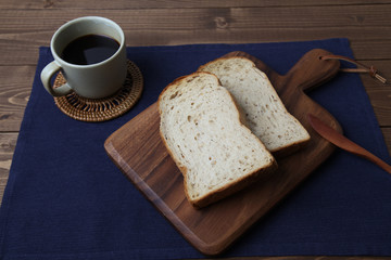 木のまな板にのせた トースト くるみ入り 食パンとコーヒー テーブル