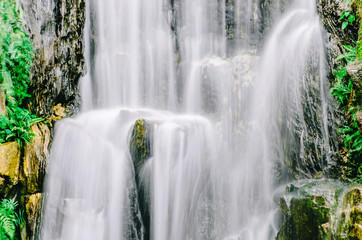 Fototapeta premium A close up view of cascading water falling over the rocks at Longshan Buddhist temple in Taipei city, Taiwan.