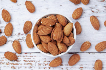 A small bowl with almond at white background