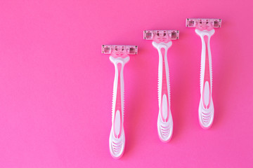 Three women's razors pink color on an a pink background. Razor for personal hygiene for hair removal