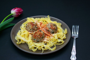 Pasta with meatballs on a dark background