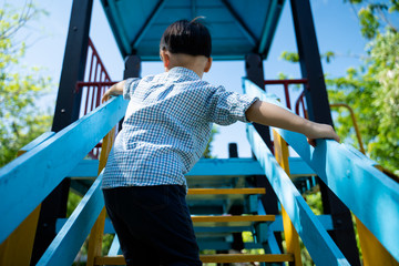 Little boy climbing on stair to play slider
