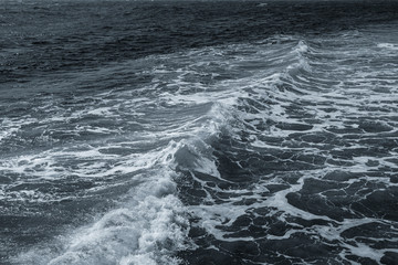 Dark blue foamy surface of dark blue sea water at stormy windy day. Beautiful marine landscape. Horizontal color photography.