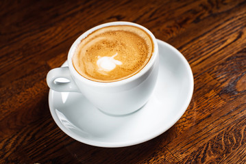 cup of cappuccino on the wooden background
