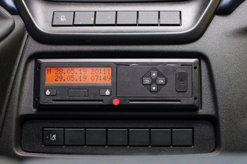 Digital tachograph display shows time difference after driver inserts the card into the device when starting shift. No personal data. Tachograph in a van
