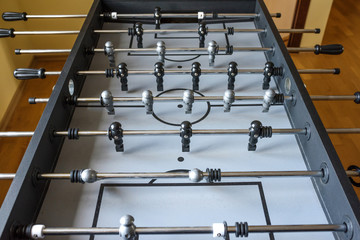 A football match of the table with black and grey players. A table game.