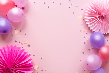 Birthday greeting card. Colorful balloons and paper flowers on pink background. Festive or party background. Flat lay style. Copy space for text.