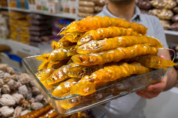 Sweet delicious churchkhela. Oriental sweets on a glass tray at the man