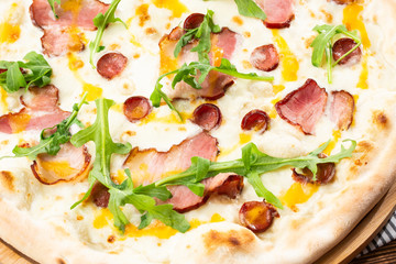 Pizza with ham , arugula (salad rocket), rucola and mozzarella  on  wooden background close up. Italian cuisine.