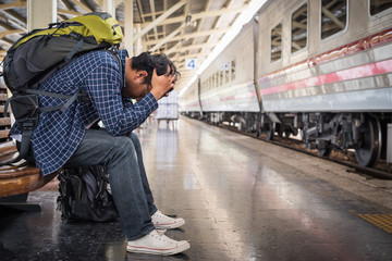 Asian depressed traveler mistakes a train at train station
