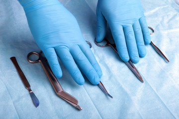 Detail shot of sterilized surgery instruments with a hand grabbing a tool ,