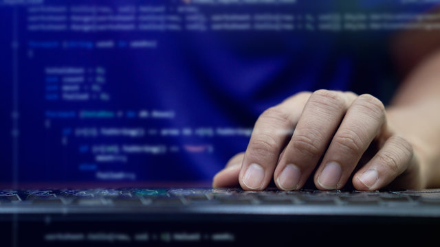 close up programmer man hand typing on keyboard at computer desktop for input coding language to software for fix bug and defect of system in operation room , development of technology concept	
