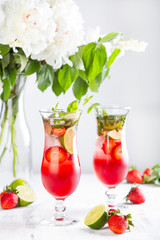 Pink lemonade with strawberries, lime, basil and mint